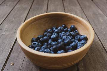 Wooden deep bowl with ripe, large, juicy and bright pigeon.