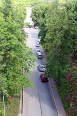 There are many cars parked on the side of the road.