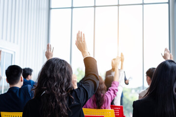Business person raising hand during seminar. Hand up in conference asking to answer a question in business meeting room and seminar class.