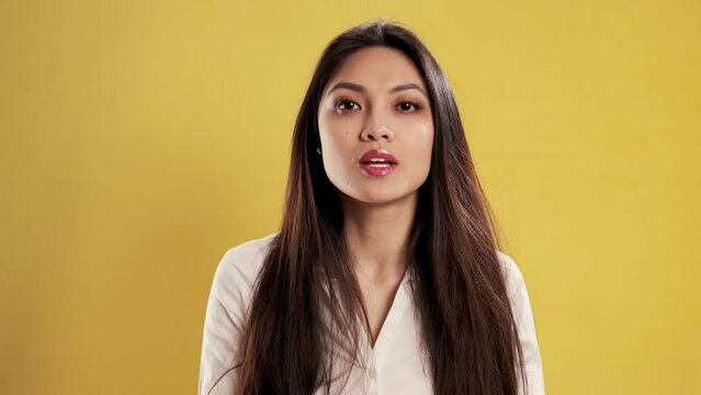 Asian Girl with a confident smile in a studio sending a kiss to the camera - extreme slow motion shot