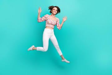 Fototapeta na wymiar Full body photo of gorgeous energetic lady jumping raise hands empty space isolated on teal color background