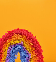 Fototapeta na wymiar Theme of celebration and fun. Good mood. A colorful, beautiful, celebrate pinata rainbow on a bright yellow background. Copy space for text.