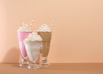 Happy birthday concept. Three delicious creamy milkshakes with colored sprinkles. Copy space for text.