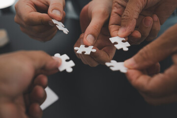 Business team handle a piece of white puzzles that are about to drop to get a complete worksheet -...