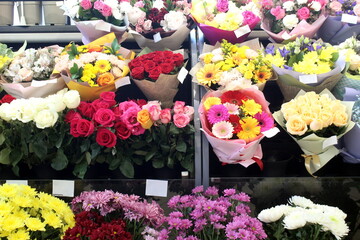 In the shopping center there is a showcase with many bouquets of flowers.