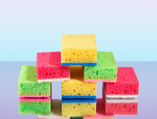 Lots of colorful new soft sponges for washing dirty dishes and some appliances lay on the surface.