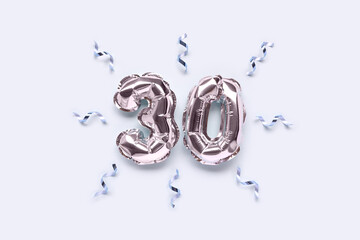 Number 30 silver inflatable balloons with ribbons confetti on a blue pastel background.