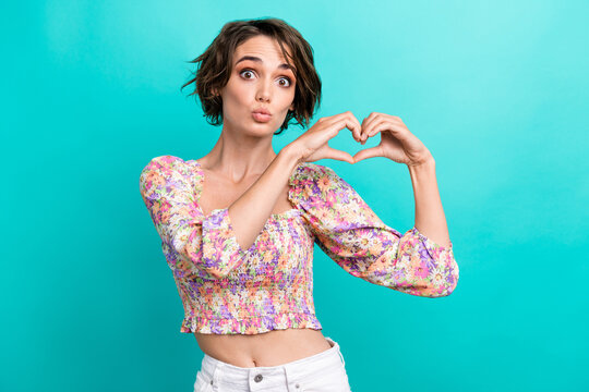 Photo of pretty lovely lady pouted lips kiss arms fingers demonstrate heart symbol isolated on teal color background