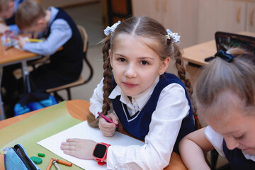 Schoolgirl at the desk in classroom in school