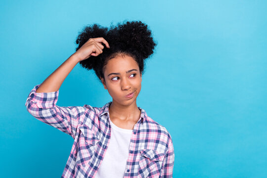 Portrait of clever smart teenager afro hair plaid shirt finger on head thoughtfully look empty space isolated on blue color background