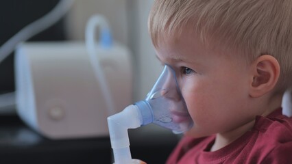 Funny boy breathing through an inhaler mask.