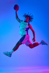 Full-length dynamic image of young professional athlete, basketball player in motion during game...