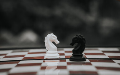 chess knight figure in competition success play. strategy, management, or leadership concept. knight challenge center. Pieces on the chessboard. falling pieces on chessboard  © sumblistan