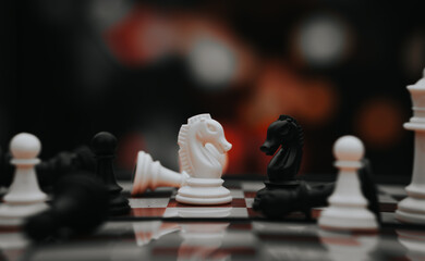 chess knight figure in competition success play. strategy, management, or leadership concept. knight challenge center. Pieces on the chessboard. falling pieces on chessboard  © sumblistan
