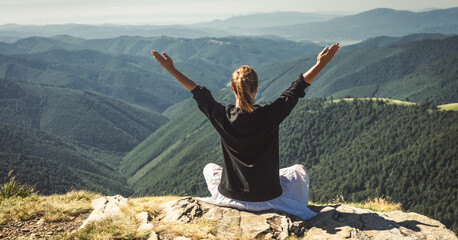 Young woman on the top of mountain