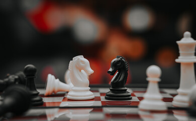 chess knight figure in competition success play. strategy, management, or leadership concept. knight challenge center. Pieces on the chessboard. falling pieces on chessboard  © sumblistan