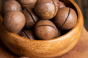 Unpeeled macadamia nuts on a wooden table