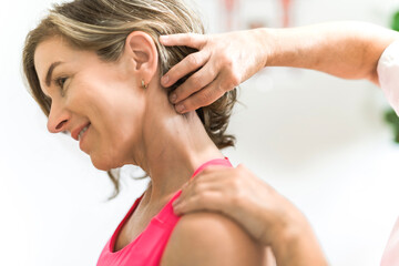 elderly Physiotherapist working with sporty patient in clinic