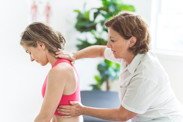 elderly Physiotherapist working with sporty patient in clinic