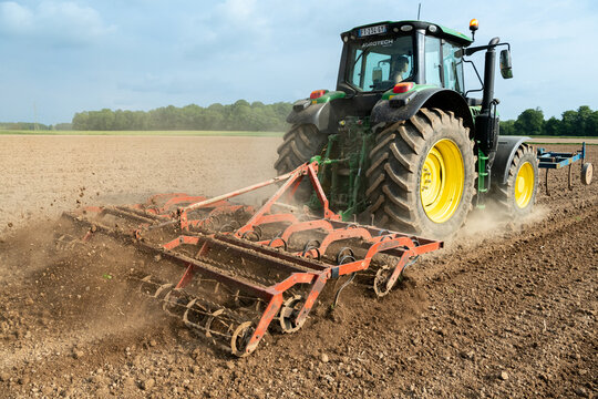 Travail du sol avant semis. Passage d'un rouleau vibroculteur brise-mottes. Agricultrice au volant du tracteur