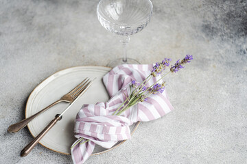 Decorative flowers in vase with fork and knife on white plate