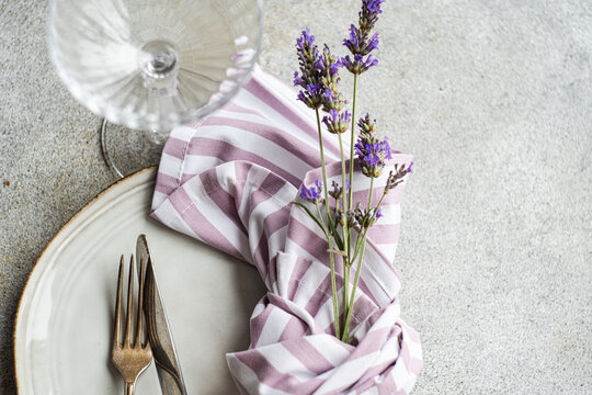 Decorative flowers in vase with fork and knife on white plate