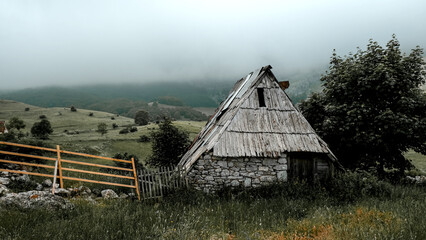 Old wooden house with fence in the Lukomir village in Bosnia and Herzegovina, gloomy day