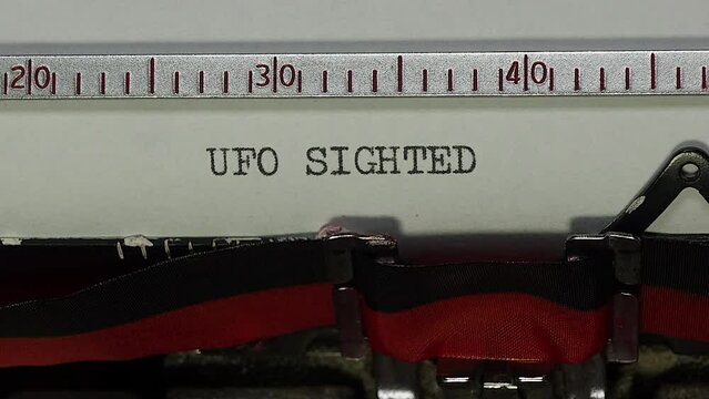 Sighting a UFO unidentified flying object. Zoom and turn in to typing UFO SIGHTED on an old manual typewriter.