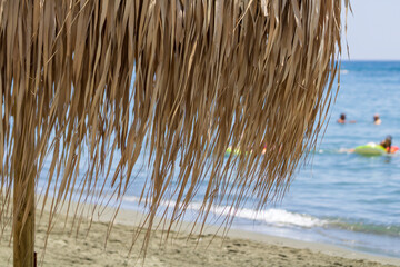 Close-up of palm umbrella on sandy sea beach 