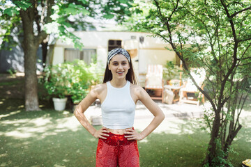Happy hippie girl is having a good time in a camper trailer. Holiday, vacation, trip concept.