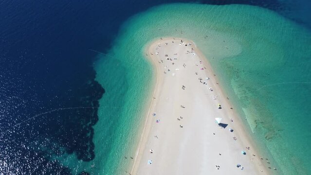 Aerial view of Zlatni Rat (Golden Horn or Golden Cape), famous beach on Brac Island in Croatia, with people swimming. Tourists enjoying summer holidays in Europe. Croatian destination on Adriatic Sea