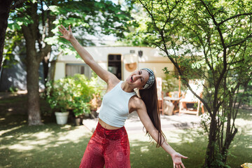 Happy hippie girl is having a good time in a camper trailer. Holiday, vacation, trip concept.