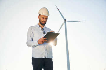 Front view. Service engineer is on the field with windmills