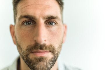 Close-up daylight portrait of young smiling handsome man isolated on gray background