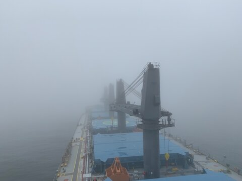 View from the bridge of the handymax bulk carrier to the holds in the fog. Large cargo ship in the river