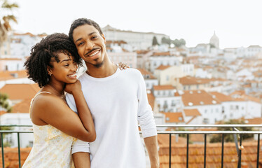 Cheerful young african american woman hugging man in city, enjoy date and travel, outdoor