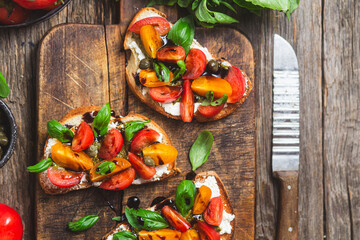 Sandwich with tomatoes, pesto and balsamic sauce on a wooden board