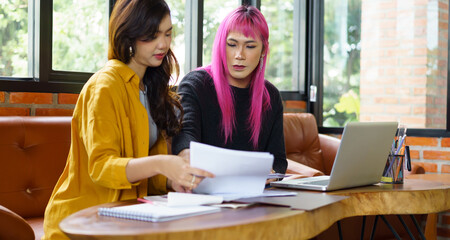 LGBTQ+ transgender man Beautiful Authentic Specialist with Pink Hair and Non-binary trans working together Working Design in creative workplace team work colleagues Gender equality