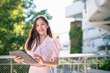Fototapeta premium Shot of elegant young business woman smiling and using tablet.