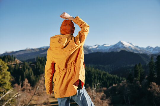 Autumn Woman Standing With Her Back Up With Her Hands In The Air Hiking In The Mountains And Happiness In A Yellow Cape Full-length Standing In Front Of The Trees And Mountains In The Sunset, Freedom