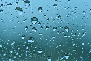 Lots of raindrops on the window. Rainy season concept. Climate change. Wet in rain. Focus on water droplets on window.