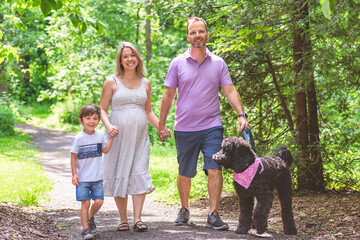 Family together in the summer park. Woman is pregnant