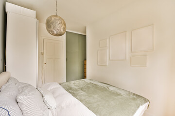 a bedroom with a bed and pictures hanging on the wall in front of the bed, along with a lamp over the headboard