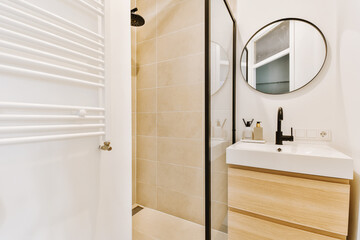 a modern bathroom with beige tile and white fixtures on the walls, along with a wooden cabinet under the sink is next to the