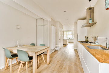 a kitchen and dining area in a house with wood floors, white walls and light hardwood flooring the room is very clean
