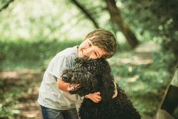 boy with a goldendoodle dog in the park