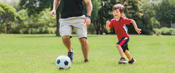Young soccer player having fun on a field with his father
