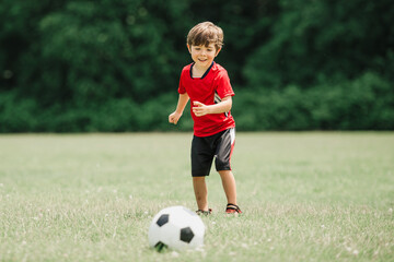 Young soccer player having fun on a field with ball
