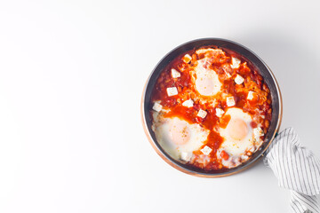 Shakshuka made of poached eggs in tomato pepper sauce