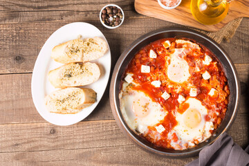 Shakshuka made of poached eggs in tomato pepper sauce
